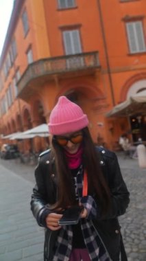 Genç bir turist kız mutlu bir şekilde bir Avrupa şehrinin sokaklarını keşfediyor. Yüksek kalite 4k görüntü