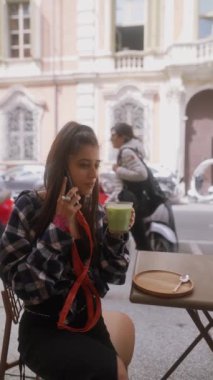 Çekici genç bir turist İtalya 'nın Bologna kentindeki bir restoranın terasında otururken telefonla konuşuyor. Yüksek kalite 4k görüntü