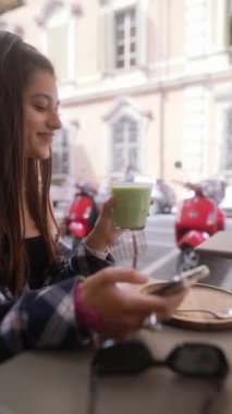 İtalya 'nın Bologna kentindeki bir restoranın terasında oturan genç ve güzel bir gezgin telefonuyla konuşuyor. Yüksek kalite 4k görüntü