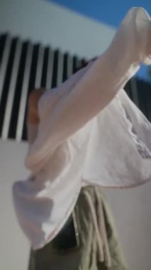 Genç bir bireyin dinamik bir sahnesi. Çağdaş bir kıyafetle enerjik bir şekilde dans ediyor. Şık, kentsel bir arkaplana karşı..