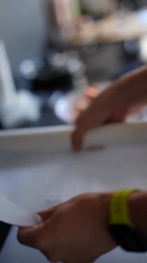 Modern bir ev ofisinde, yakın plan çekimde masa üzerinde çalışan, odaklanmış ve etkili kağıtlar görülüyor.