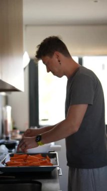 Bir adam modern bir mutfakta taze sebze pişiriyor, sağlıklı bir yaşam tarzı ve mutfak konseptini yansıtıyor.