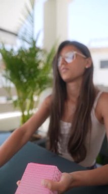 Açık havada, yeşil alanlarla çevrili, rahat ve güneşli bir ortamda oyun oynayan genç bir kadın..