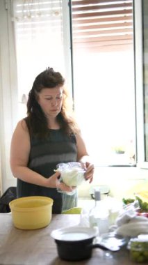 Mutfağında taze bir salata hazırlayan bir kadın. Mutfak malzemeleri ve mutfak malzemeleriyle çevrili..