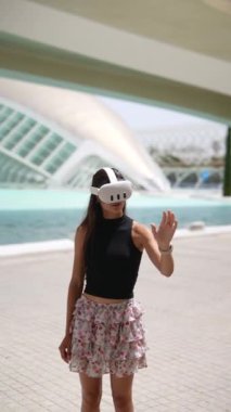 Gelecekçi bir şehirde, bir kadın, teknolojiyi kentsel çevre ile birleştirmek için bir VR kulaklık kullanır.