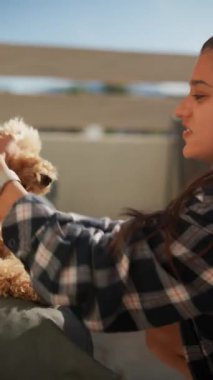 Tüylü köpeğiyle genç bir kadın güneşli havada dışarıda vakit geçirir, bağ kurar ve oynar..