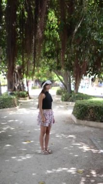 Bir kadın, yemyeşil ve ağaçlarla çevrili sanal gerçeklik kulaklığını kullanarak parkı keşfediyor..