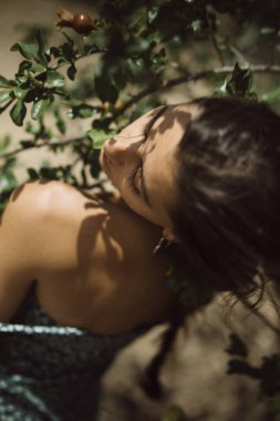 Doğayla etkileşime geçen bir kadının, yukarıdan bakıldığında daldaki bir salyangozun sakin bir şekilde ele geçirilmesi..