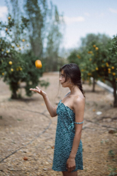 Side View Woman Dress Juggling Orange Fruit Orchard Trees Background Royalty Free Stock Images