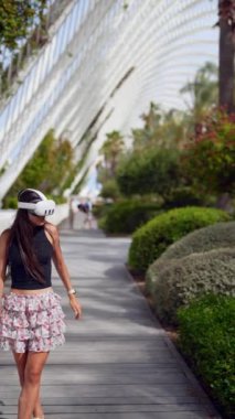 Fütüristik bir şehir parkında, bir kadın modern teknoloji ve yeşilliğin ortasında dans etmekle meşgul.