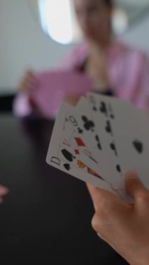 Oyuncular arasında kart oyunlarına ve stratejik kararlara yoğun bir odaklanma ile evde canlı bir poker oturumu