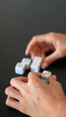 Ayrıntılı yakın çekim görüntüleri, beyaz zarları karanlık bir yüzeyde manipüle ederek dokunsal bağlantıyı vurguluyor.