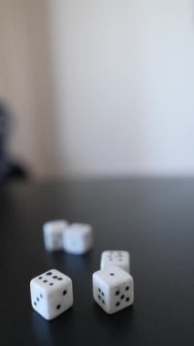 Zar ve ellerin yakın plan görüntüleri oyun ve etkileşimli boş zaman aktiviteleri için siyah minimalist bir masa üzerinde