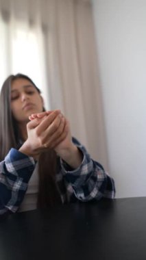 Ekose gömlekli bir kadın siyah bir masada zar atıyor. Yüzü bulanıkken, elleri ve zarları odaklı.