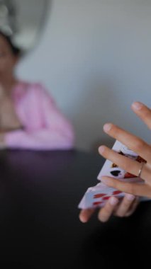 Oyuncuların elinde bir deste kalp kartı olan bir iskambil oyununun kapanışı devam ediyor.
