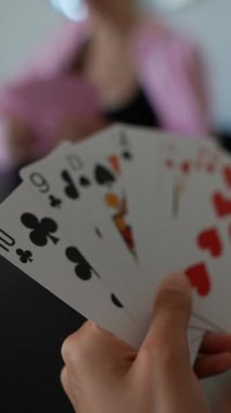 Arkadaşlar bir kart oyununun keyfini çıkarıyorlar, gülümsemelerini paylaşıyorlar ve rahatlatıcı ve birbirine bağlı bir ortam yaratıyorlar.