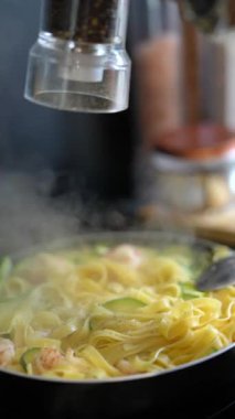 Ağız sulandıran bir tabak fettuccine makarna, karides ve kabak, taze biberli..