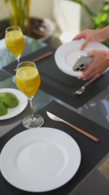 İçinde cam bir masa, meyve ve iki portakal suyu bardağı bulunan modern yemek takımı kahvaltı için mükemmel..