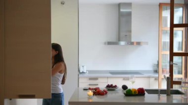 Mutfağın içinde minimalist tasarım, doğal ışık ve taze sebzeler var..