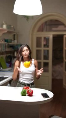 Modern mutfakta taze sebzeli dolmalık biber tutan kadın yemek pişirmek ve sağlıklı yaşam temaları için harika.