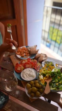 Salata, aperatifler, balkonun yanındaki ahşap masada hoş bir yemek deneyimi için ekmek.