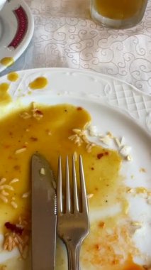 Üzerinde çatal ve bıçak olan boş bir tabağın yakından görüntüsü yemeğin bitirildiğini ve tüketildiğini gösteriyor.