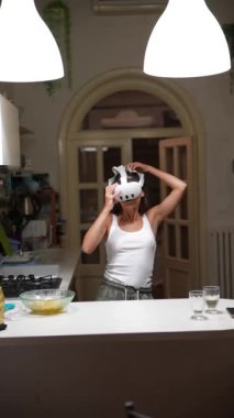 Neşeli bir ruh hali içinde beyaz atlet giyen ve modern dekorlu şık, aydınlık bir mutfakta maske takan biri..