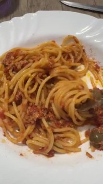 Beyaz tabakta servis edilen taze pişmiş bolonez soslu spagetti. Keyfini çıkarmaya hazır..