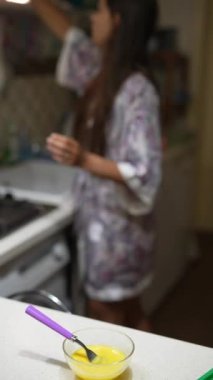 Mutfakta bir kadın tezgahta çırpılmış yumurtalarla yemek pişiriyor. Yemek hazırlığı yapıyor.