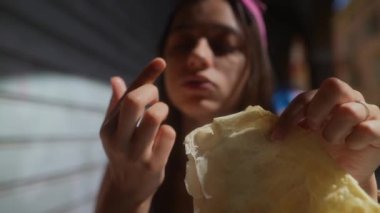 Pembe şapkalı genç bir kadın dışarıda pamuk şekerin tadını çıkartıyor. Kaygısız bir sevinç anının tadını çıkarıyor.