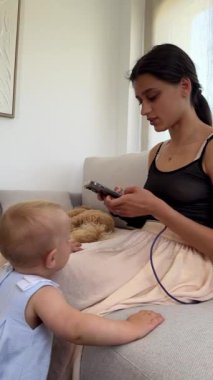 Bir anne ve çocuğun huzur içinde evde bir araya gelip çeşitli aktivitelere katıldığı iç açıcı bir sahne.