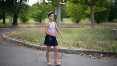 Kendine güvenen genç bir kadın hareketli bir şehir kaldırımında yürüyor, gururla canlı şehir modasını sergiliyor.