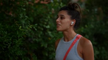 Gri giyinmiş genç bir kadın büyüleyici açık hava müziğinin tadını çıkarıyor, canlı bir şehir yaşam tarzını somutlaştırıyor.