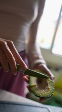 Yemek pişirmek ya da yemek hazırlamak için dilimlenen taze bir avokadonun yakın plan çekimi.