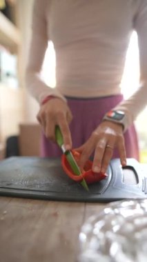 Parlak ve neşeli bir mutfakta, bir insan sağlıklı bir yemek için taze ve renkli sebzeler hazırlıyor.