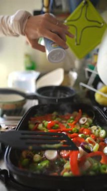 Çağdaş bir mutfak ortamında taze sebzeler özenle sotelenir.