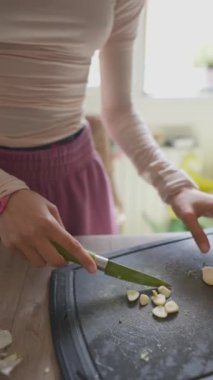 Sıcacık bir mutfak ortamında taze sebzeleri ustalıkla doğrayan biri. Hayat dolu.
