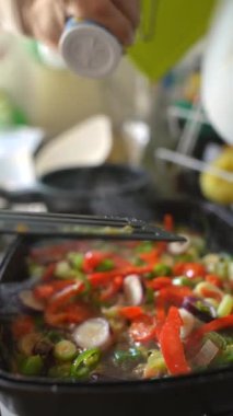 Taze sebzelerin rengarenk bir karışımı bir mutfakta tatlandırılıp soteleniyor.