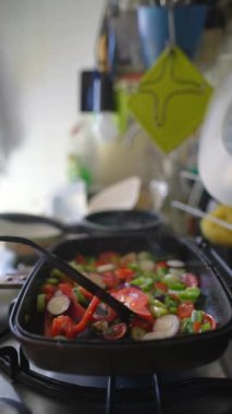 Modern ve şık bir mutfak ortamında canlı ve renkli taze sebzeler cızırdıyor.