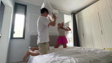 Bir çift, modern, şık ve rahat yatak odalarında birlikte bir yatak yapıyor.