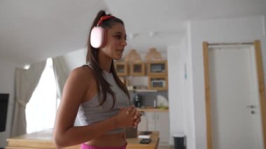 Kulaklığa takılmış, yaratıcı sürecine dalmış rahat ve davetkar bir ortamda yaşayan bir kadın.