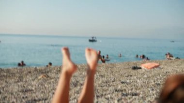 Güneşlenenlerin, yumuşak kumun ve el değmemiş suların olduğu sakin bir sahil sahnesi. Yaz tatili için ideal.