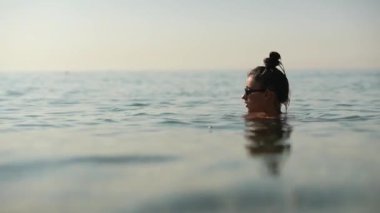 Şok edici bir gün batımında sakin sularda yüzen huzurlu bir an, gerçek bir iç huzur ve neşeyi yansıtıyor.