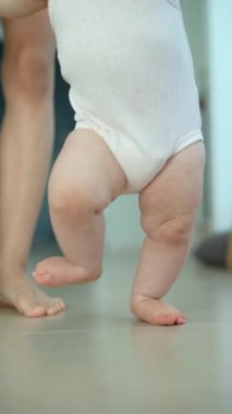 Neşeli bir bebek, şık ve modern bir iç mekanda yürüyüş becerilerini geliştiriyor, değerli bir dönüm noktasını yakalıyor.