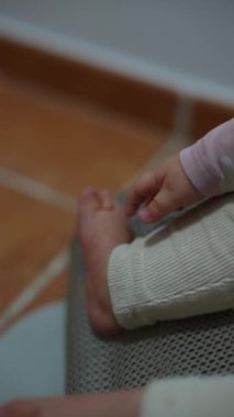 Küçük bir çocuğun narin bir yakın çekimi küçük bir el hafifçe küçük ayaklarına dokunuyor, saf masumiyeti güzel bir şekilde vurguluyor.