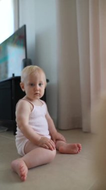 Çekici bir bebek, merak ve saf masumiyetle dolu güzel bir anı içeride yakalıyor.