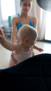 Neşeli bir an bir anneyi ve tapılası bebeğini sıcak bir ortamda değerli vakit geçirirken gösterir.