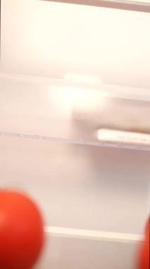 Parlak kırmızı, olgun domatesler bir buzdolabında güzelce depolanmış tazeliklerini ve canlılıklarını sergiliyorlar.