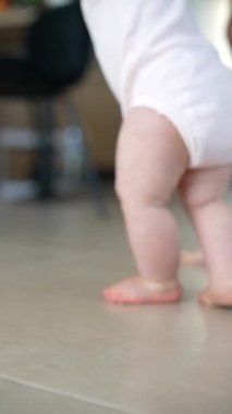 Meraklı bir bebek fayanslı zeminde yürümeyi öğrenir. Bu da erken çocukluk keşiflerinin neşesini gösterir.