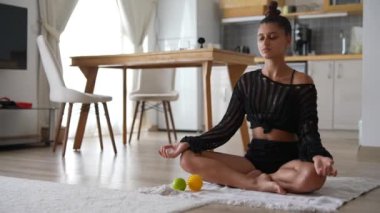 Konforlu evinde, bir kadın huzur içinde meditasyon yapar. Huzur veren canlı meyvelerle çevrili.